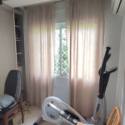 וילון בהיר תלוי על חלון עם סורגים