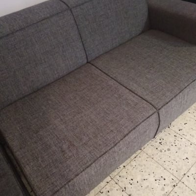 ספה אפורה עם כתמים על הריפוד