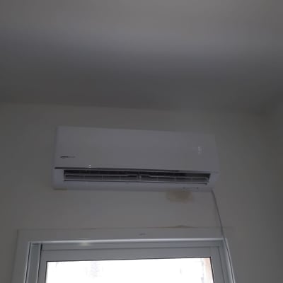 מזגן מותקן על קיר מעל חלון