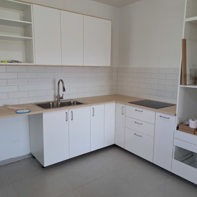 מטבח חדש עם ארונות לבנים ומשטח עבודה מעץ