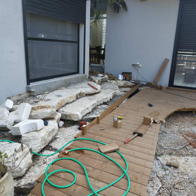 דק עץ בבנייה עם כלים וצינור ירוק