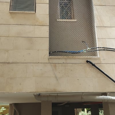 רשת מתכת מותקנת על חלון למניעת כניסת יונים