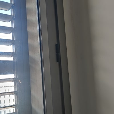 תריסים אפורים על חלון זכוכית עם מסגרת מתכת