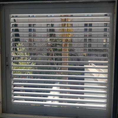 תריסי אלומיניום בחלון עם נוף חיצוני