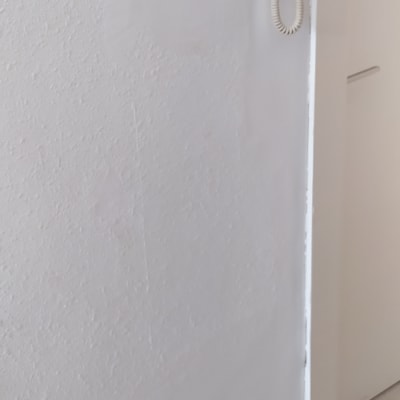 קיר צבוע בלבן עם סימני צבע טריים