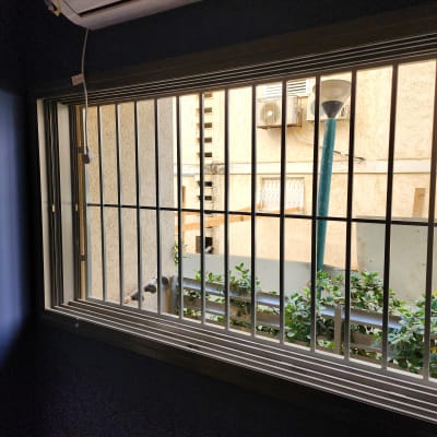 חלון עם סורגים מתכתיים על רקע קיר חיצוני