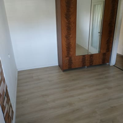 רצפת פרקט עץ בהירה בחדר עם ארון מראה