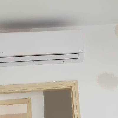 מזגן קיר לבן מותקן מעל דלת