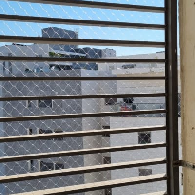 רשת מתכת על חלון למניעת כניסת יונים