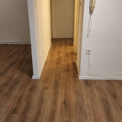 רצפת פרקט עץ כהה במסדרון מואר