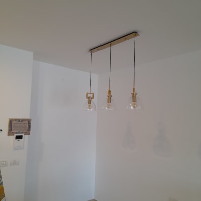 שלושה גופי תאורה תלויים מהתקרה עם כבלים חשמליים