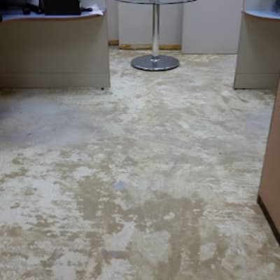 חדר עם רצפת פרקט בהירה ושולחן מתכת