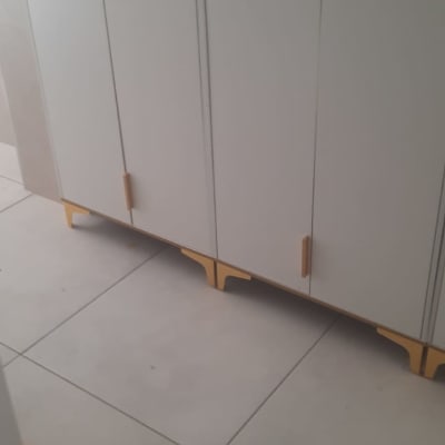 ארון לבן עם ידיות עץ על רצפת קרמיקה