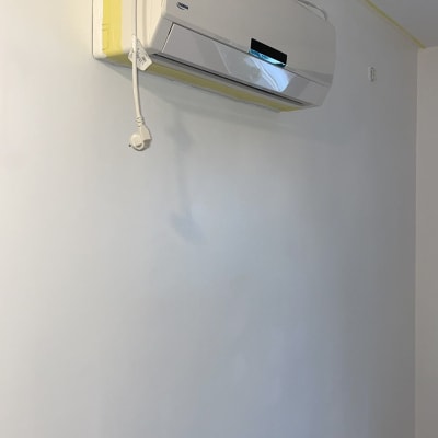 מזגן מותקן על קיר עם חוט חשמל תלוי