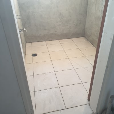 חדר עם רצפת אריחים חדשים וקירות בטון חשופים