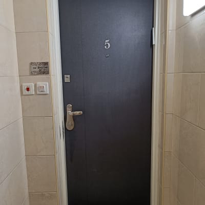 דלת מתכת כהה עם מספר 5 ומנעול כסוף