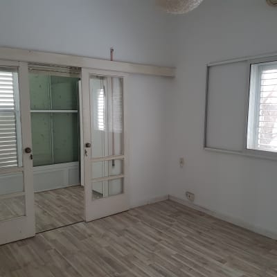 חדר עם דלתות זכוכית ורצפת עץ