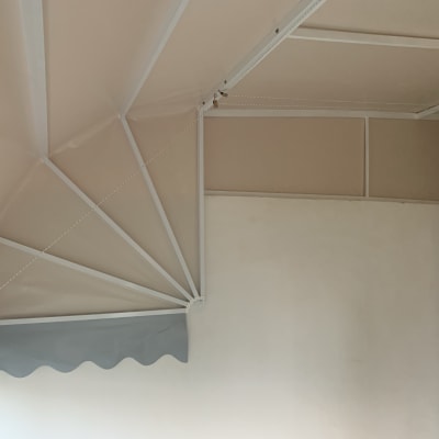 סוכך בד עם מסגרת מתכת לבנה על קיר