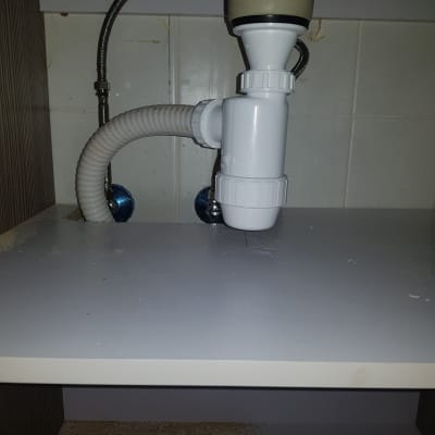 צינור ניקוז לבן מתחת לכיור במטבח