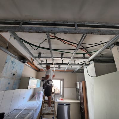 עבודת גבס בתקרה עם מסגרת מתכת וקירות חשופים