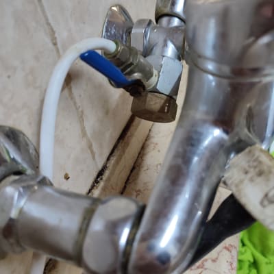 ברז מתכת עם צינור לבן ושסתום כחול