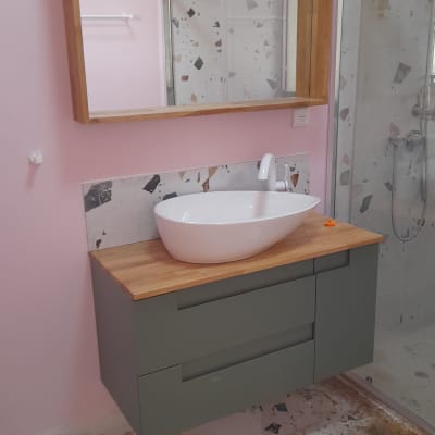 כיור חדש מותקן על ארון עץ בחדר אמבטיה