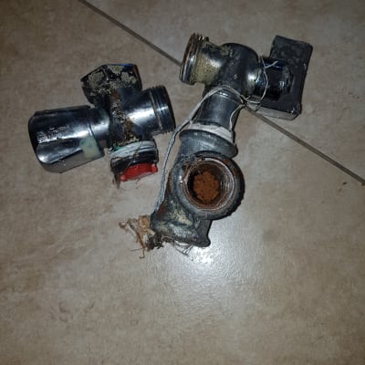 שני ברזים ישנים וחלודים על רצפה