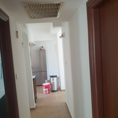 דלי צבע אדום במסדרון עם קירות לבנים