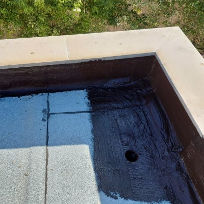 גג עם זפת שחורה וחור ניקוז בפינה