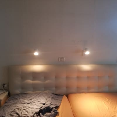 שני מנורות קיר מעל מיטה עם מתג חשמל