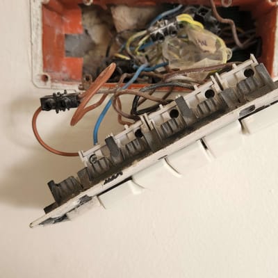 חוטי חשמל חשופים ותיבת חיבורים בקיר