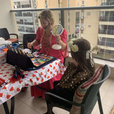 אישה צובעת פנים לילדה במסיבת יום הולדת