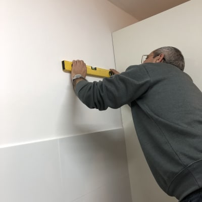 אדם משתמש בפלס על קיר לבן