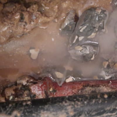 צינור מים דולף עם נזילה באדמה רטובה