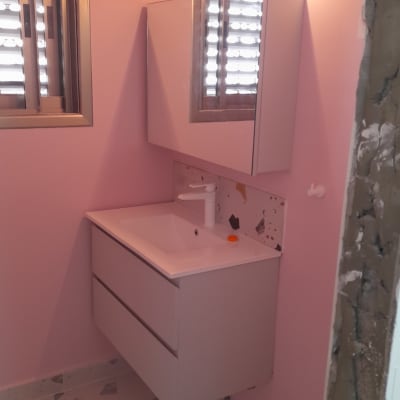 שיפוץ חדר אמבטיה עם כיור חדש וקיר ורוד