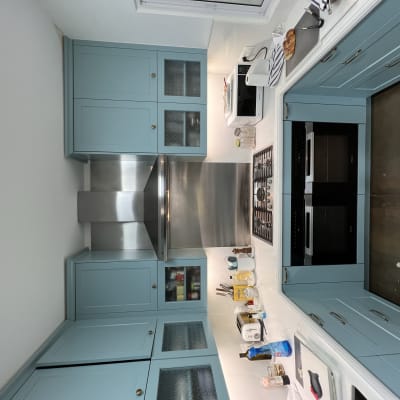 מטבח עם ארונות כחולים, כיריים וכלי עבודה