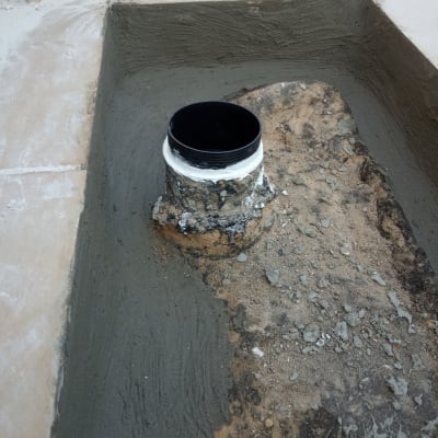 צינור שחור עם איטום בטון סביבו