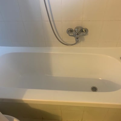 אמבטיה לבנה עם ברז כרום וקיר אריחים