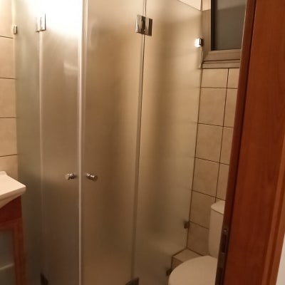 מקלחון זכוכית עם דלתות מתכת בחדר אמבטיה