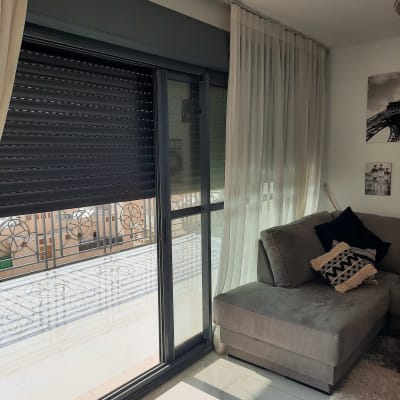 חלון אלומיניום עם תריסים סגורים ומעקה חיצוני