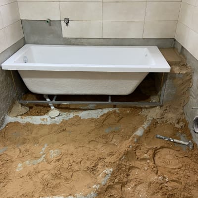 אמבטיה מותקנת בחדר רחצה בשיפוץ עם חול וכלים