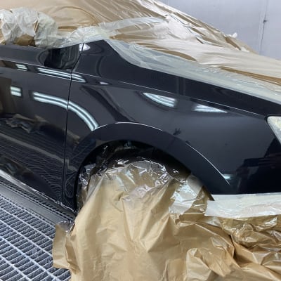 רכב מכוסה בניירות להגנה במהלך צביעת גוף