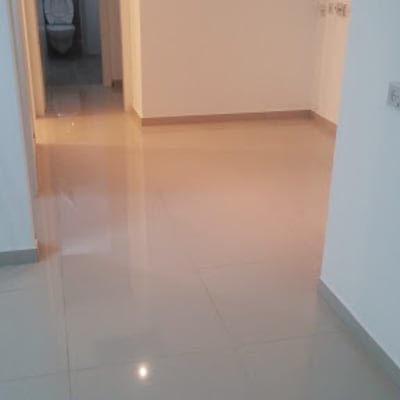 רצפת אריחים מבריקה במסדרון עם דלת פתוחה לשירותים