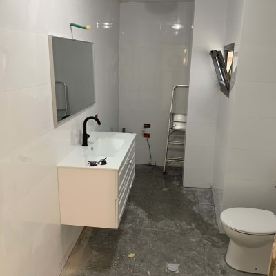 חדר אמבטיה בשיפוץ עם כיור, סולם ואסלה