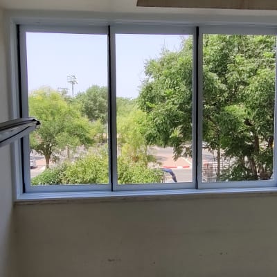 חלונות אלומיניום עגולים ומלבניים עם נוף עצים