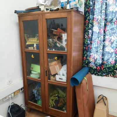 ארון עץ עם דלתות זכוכית מלא בחפצים שונים