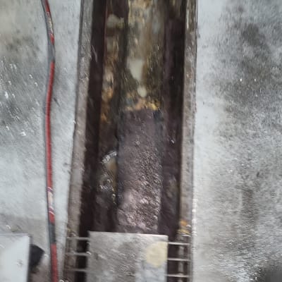 תעלת ניקוז עם צינור אדום על רצפה אפורה