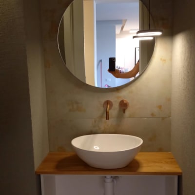 מראה עגולה תלויה על קיר בחדר אמבטיה