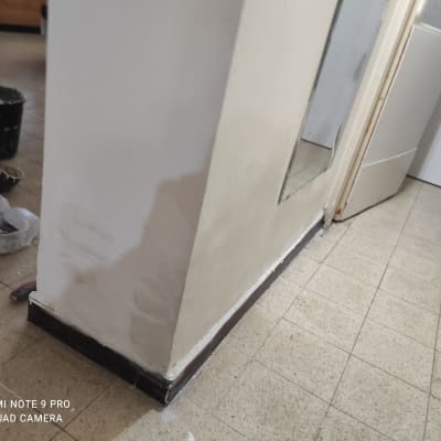 קיר צבוע חלקית עם כלי עבודה לצביעה