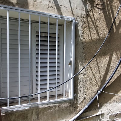 חלון עם סורגים לבנים וקווים חשמליים